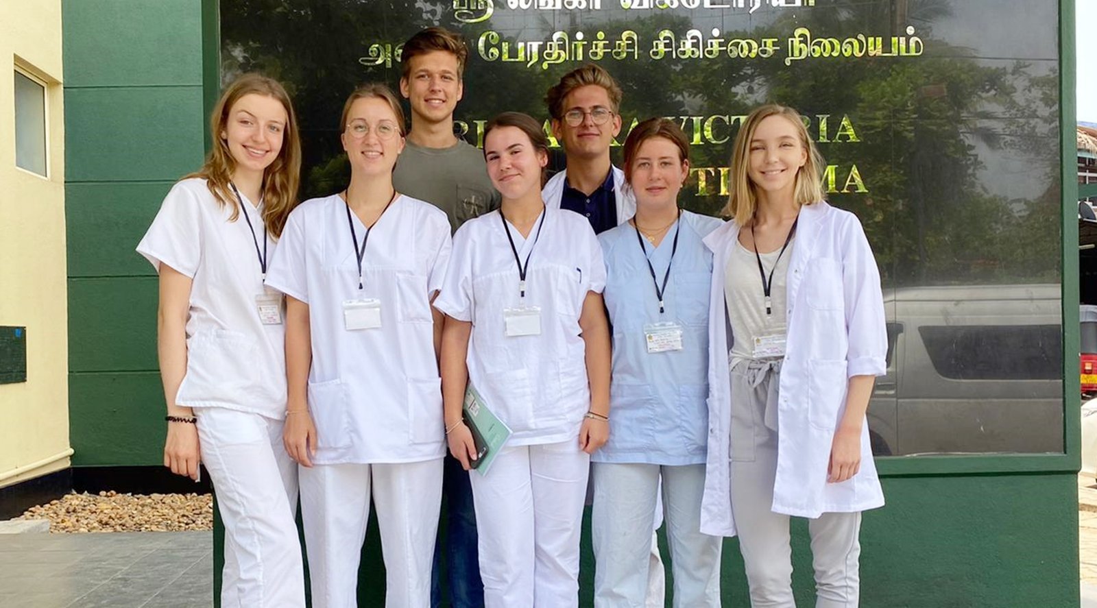 International nursing students in scrubs outside a district hospital in Sri Lanka