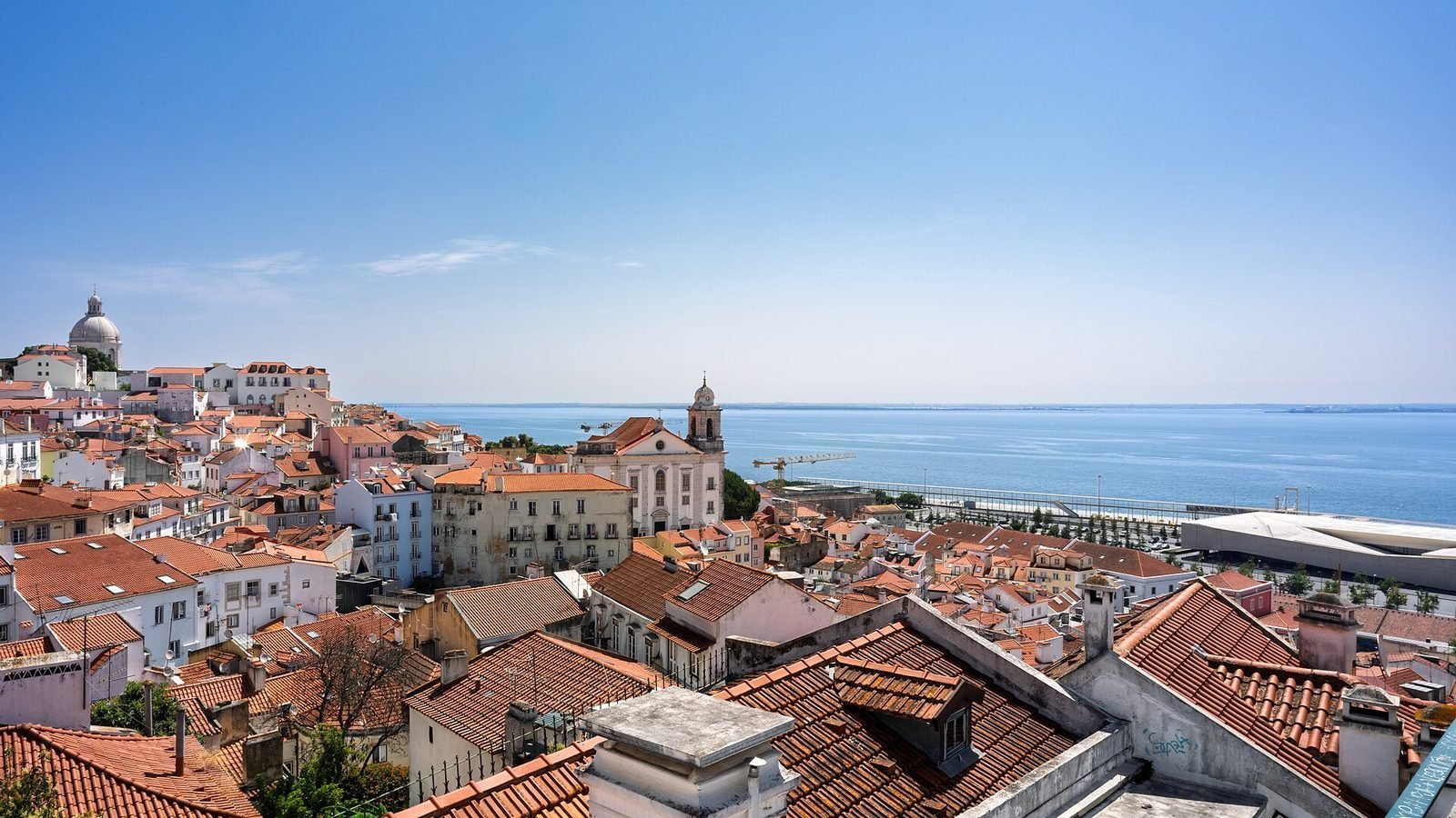 Terracotta rooftops of the Alfama district above the Tagus estuary in Lisbon